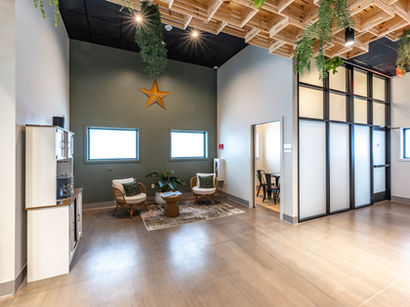 Dispensary lobby and waiting area design with wood-slat ceiling accents and natural lighting.