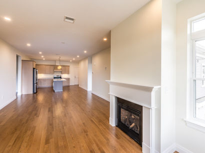 Open-concept living area with fireplace and hardwood floors in a Franklin, MA development.