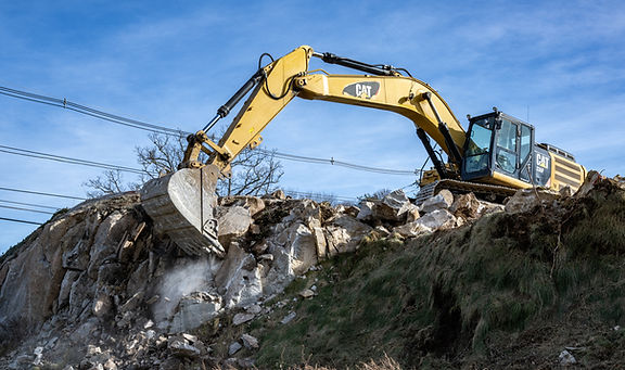 Heavy equipment performing site excavation and land development for a ground-up commercial project in Massachusetts.