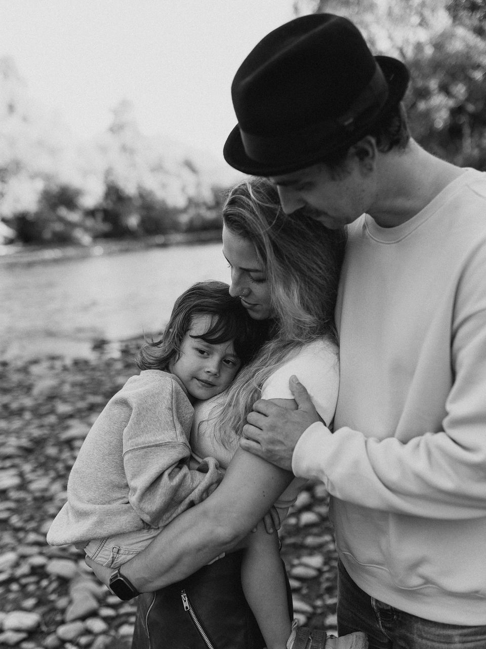 Familienfotografie, Familie ist verbunden, Kind kuschelt und lacht
