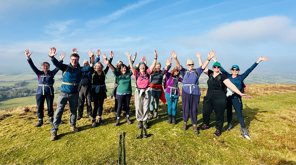 Photo of a large group of happy walkers on top of a hill