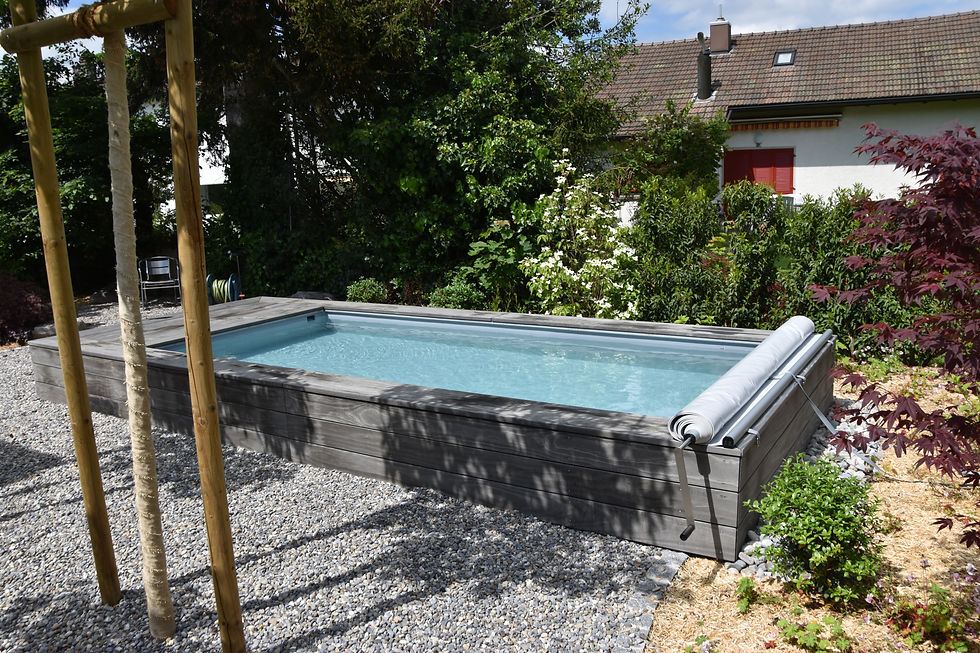 klares Wasser in einem Ecopool, die Rollabdeckung ist geöffnet. 
In der Umgebung  sind Stauden und Sträucher gesetzt.
