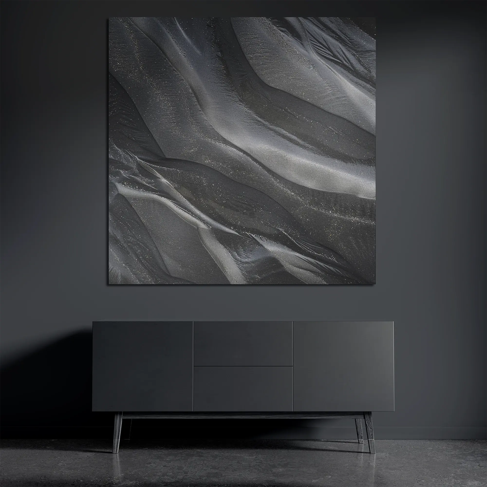 Black sand metal wall art on brushed aluminum above dark console