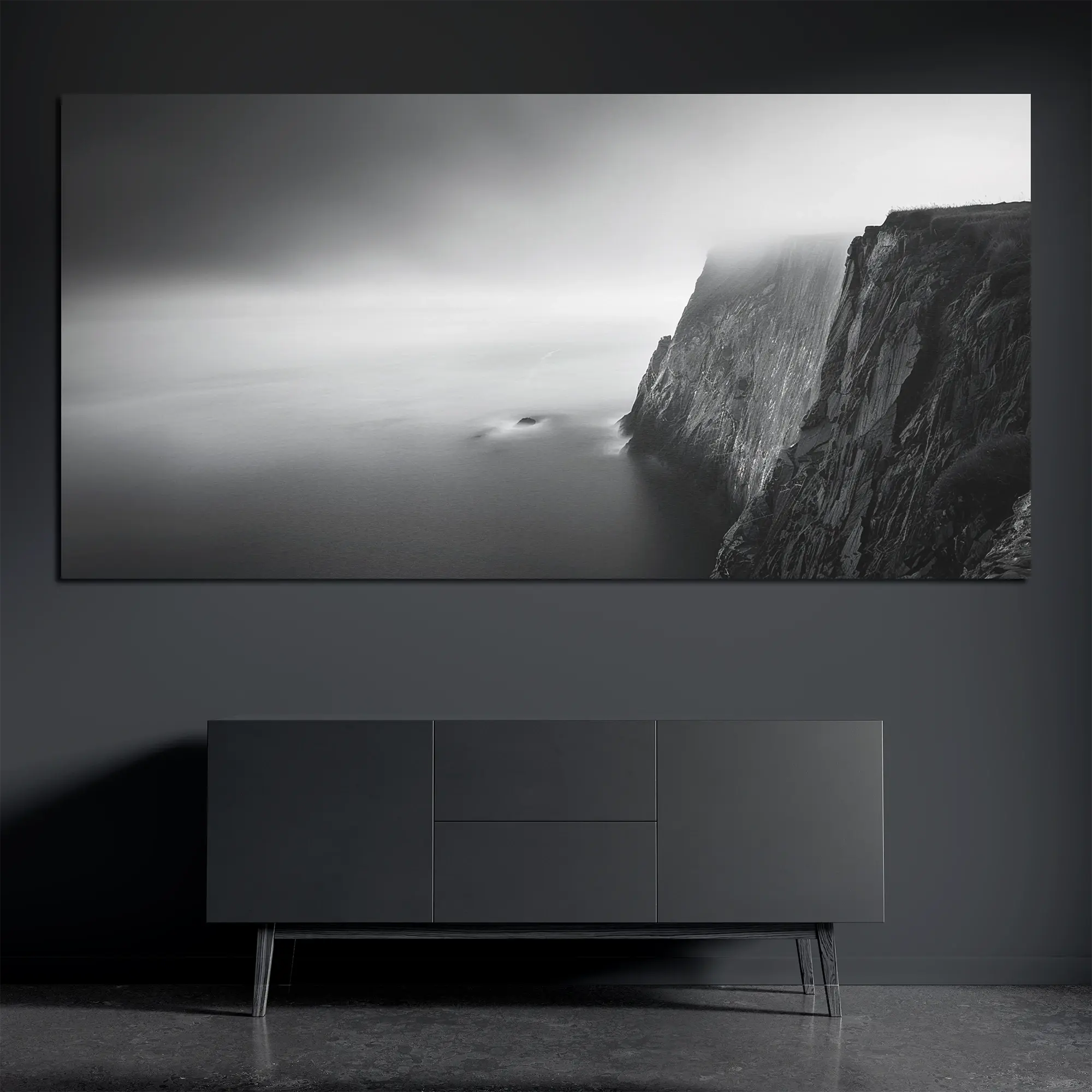 Panoramic brushed aluminum wall art with foggy cliff and ocean on dark wall above dark console