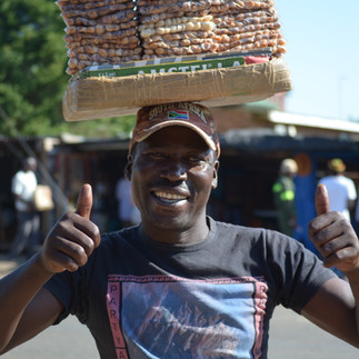 A smiling man in South Africa selling macadamia nuts.