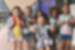 Front view of happy diverse school kids standing in outside corridor at school while a Ca