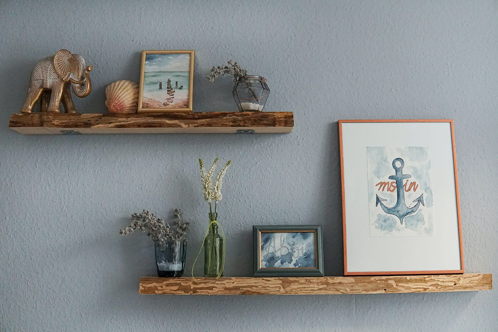 An example of how to style a shelf. The pictures, dry plants in vases and figurines are all done in the same theme: the ocean.