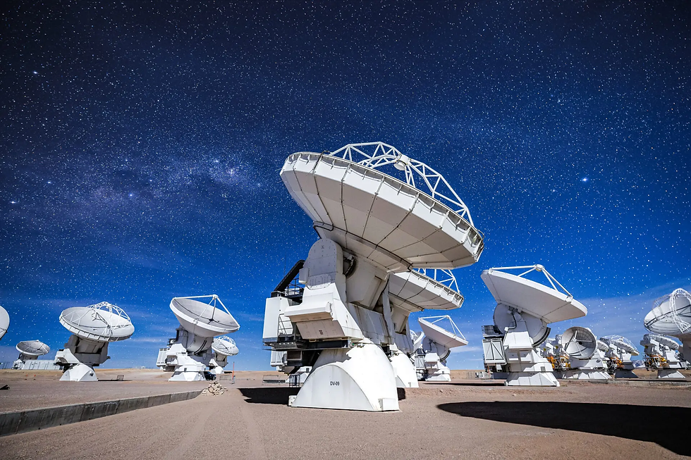 Large white radio telescopes labeled DV-09 sit in a desert observatory under a star-filled blue night sky.