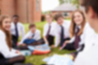 Group of high school students in Ireland in uniform sitting on grass in school grounds_ (1