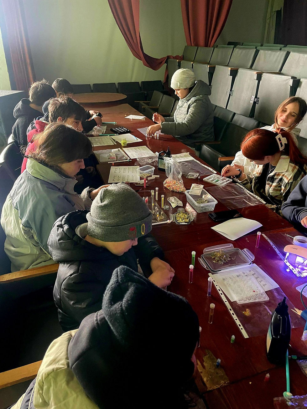 young girl happy decorating easter eggs with Ukrainian volunteer