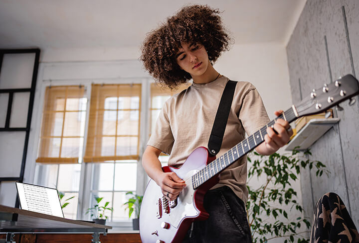 Girl playing guitar in her room
