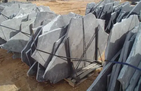 Many large piece of Blue standup flagstone placed on their side in a rack.