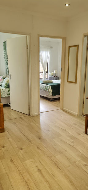 Interior view of a house with open doorways, wooden floors and rooms