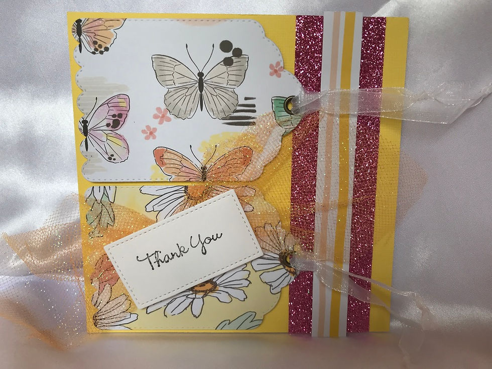 Awesome, kind of retro looking yellow card with gift tag cut outs.  The side has a white and yellow border surrounded by a glittery pink border.  To the left are two gift tags in butterfly and flowers.  They each have metal grommets and white organza ribbon tied in knots at the ends.  There is a small white stitched die cut rectangle with the message, Thank You on the flower tag.