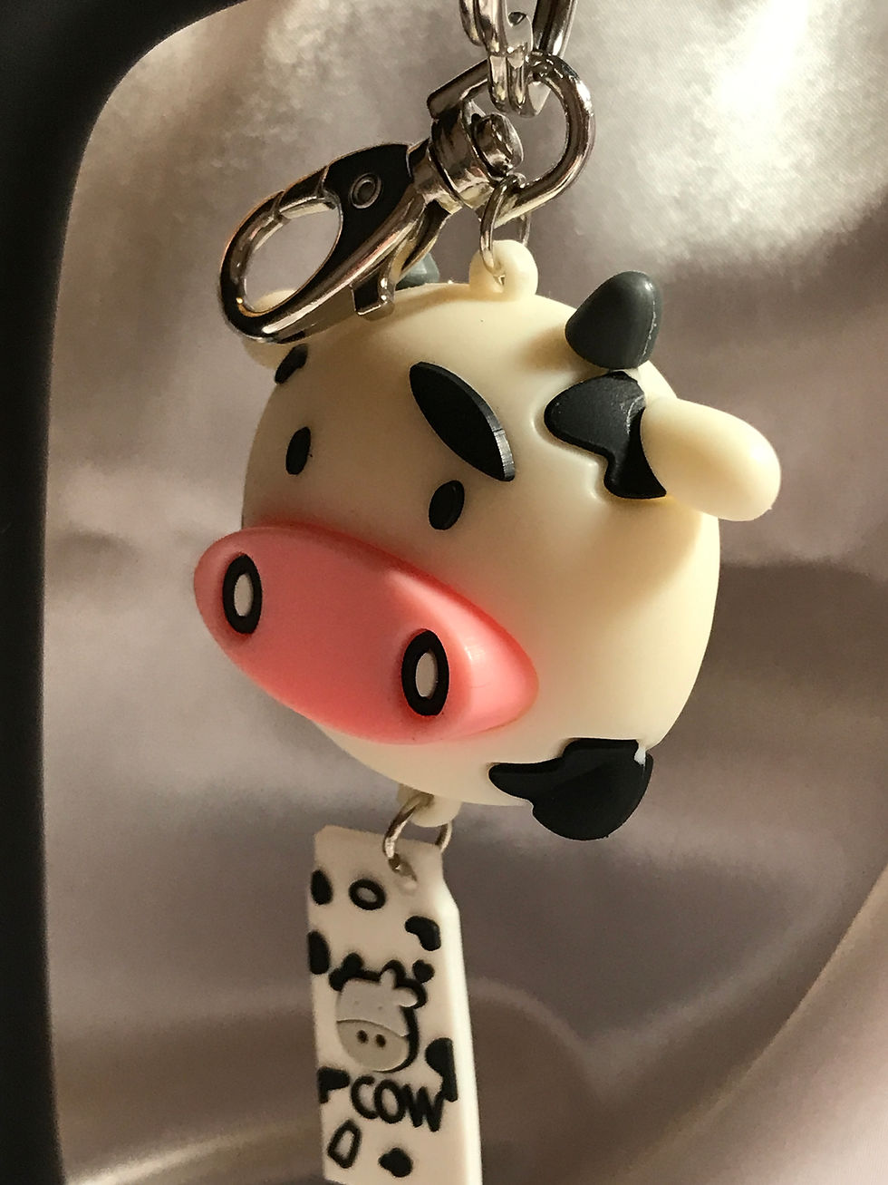 Black and white cow themed wristlet with four cow focal beads, a large silver key ring, and awesome cartoon looking black and white cow key chain, with a rubber shaped milk carton underneath, white with black spots and the work "Cow".  