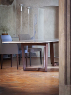 Compact dining chairs positioned around a table in a refined interior, highlighting their smaller proportions and integrated armrests within a dining environment
