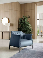 Archibald armchair by Poltrona Frau positioned in a modern interior, highlighting its curved backrest and soft seat