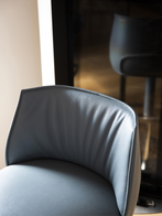 Archibald stool with steel base by Poltrona Frau shown in a refined interior, highlighting the upholstered seat and curved backrest