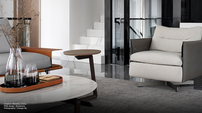Fidelio elliptical small table by Poltrona Frau designed by Roberto Lazzeroni styled within a contemporary living room interior beside a designer armchair and coffee table