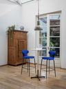 Montera Mas stool by Poltrona Frau arranged around a kitchen island showing its ergonomic shape and modern design