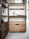 Interior view of the drinks cabinet showing shelves arranged for glasses and accessories with a drawer positioned below