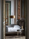 Bob coffee table styled beside a bed in a bedroom setting, illustrating its versatility as a side or occasional table with a compact form