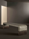 Brera bench by Poltrona Frau placed in a contemporary interior, highlighting its woven surface and sculptural form