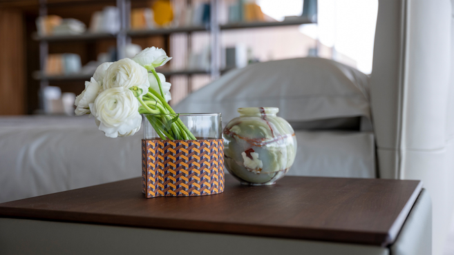 Leather-wrapped pot by Poltrona Frau from the Gli Oggetti accessories collection placed on a bedside table holding flowers as a decorative interior accessory
