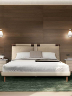 Front view of the Times bed styled with pillows and bedside lighting, highlighting its structured headboard and refined proportions