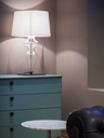Desk lamp placed on a cabinet in a living space, providing soft ambient lighting alongside surrounding furnishings
