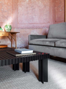Kyoto table positioned in a living space beside seating, highlighting its low profile and structured surface