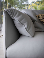 Close-up of the John-John sofa by Poltrona Frau showing the soft back cushion and refined upholstery