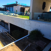 Wide view of dual custom precast coping installations visible through glass feature