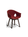 Studio image of the chair showing its sculpted seat and balanced proportions on wooden legs
