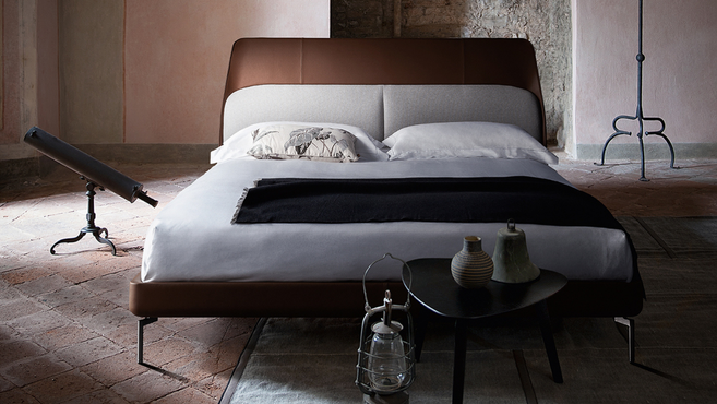 Coupe bed by Poltrona Frau designed by GamFratesi styled within a contemporary bedroom interior highlighting the upholstered headboard and refined designer craftsmanship