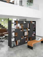 Brera bench by Poltrona Frau positioned in a modern interior with shelving, highlighting its functional and decorative role