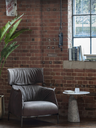 Archibald King armchair by Poltrona Frau styled in an interior with a refined setting highlighting its structured form and elevated backrest