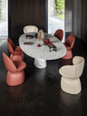 A group of small armchairs arranged around a round table in a dining setting, showcasing their compact proportions and suitability for social seating environments