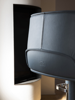Close-up of the Archibald stool with steel base by Poltrona Frau showing the rear of the seat and smooth upholstery