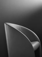 Close-up of the Intervista armchair by Poltrona Frau showcasing its curved backrest and continuous surface