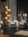 Albero bookcase placed within a contemporary living space, showing its vertical structure with rotating shelves styled with books and objects beside a seating area