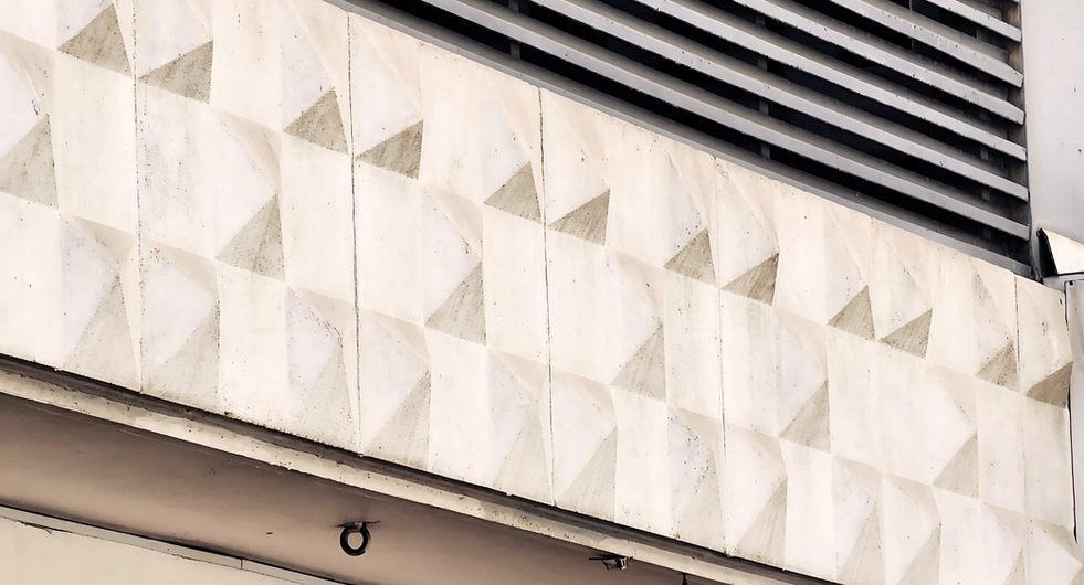 Macro of diamond-relief precast cladding showing crisp chamfers, consistent module size, neat joints and a refined off-form finish.