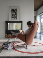 Angled view of the Downtown lounge armchair by Poltrona Frau showing its extended backrest and footrest