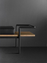 Side view of the T904 bench showing the relationship between the upholstered seat and the extended tray surface supported by a slim frame