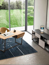 Table lamp placed on a side table beside a seating area, providing focused ambient lighting within a bright interior
