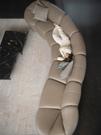 Parka modular sofa by Poltrona Frau arranged in a curved configuration within a contemporary living space, highlighting its soft sculptural form