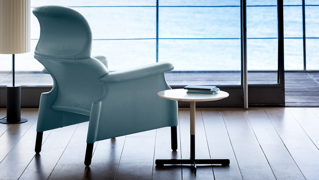 Bob coffee table by Poltrona Frau designed by Jean-Marie Massaud displayed beside a lounge chair within a contemporary residential interior
