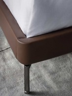 Detail of the Coupé bed base showing the upholstered frame elevated by a slender supporting leg