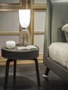 Fiorile small table with drawer positioned next to a chair with objects on top, showing its role as a compact storage surface