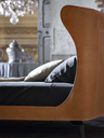 Angled view of the Mamy Blue bed showing the curved headboard wrapping into the upholstered frame